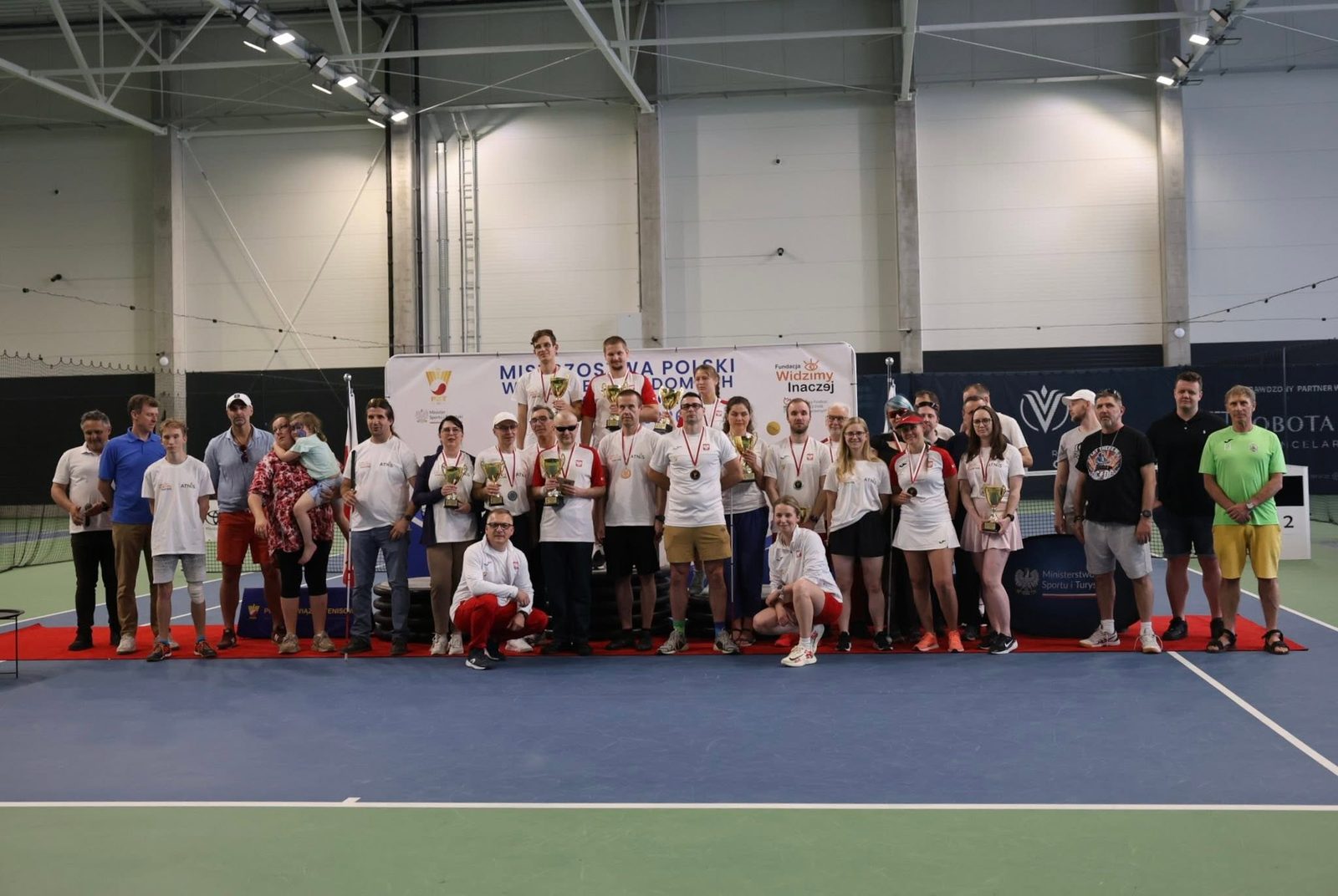 Zawodnicy III Mistrzostw Polski w Blind Tenisie z pucharami na korcie Leszno Tenis Klub